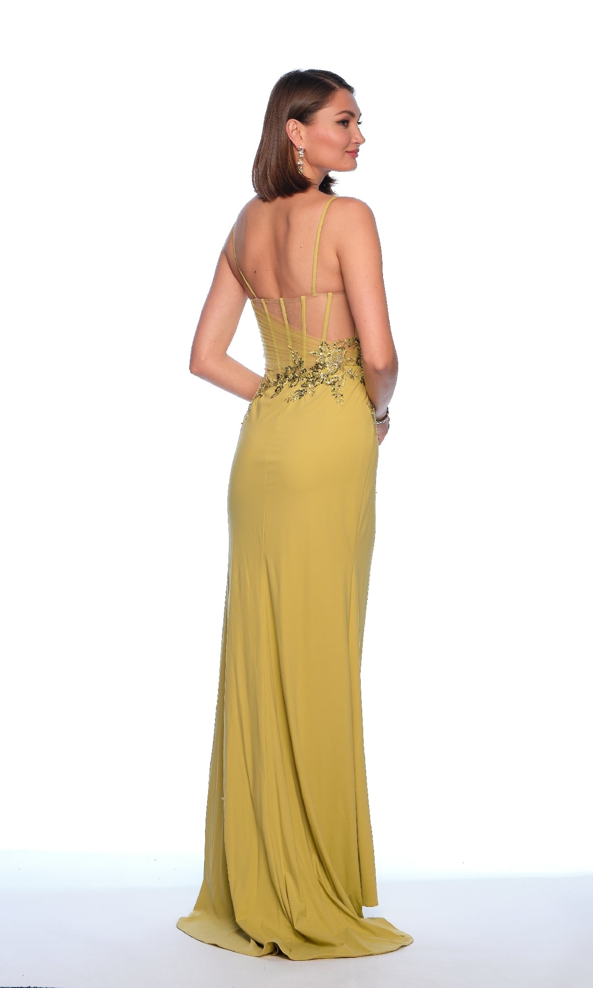 A woman faces away, wearing the Dave and Johnny 12018 Lime Green Prom Dress with thin straps and floral details on the fitted bodice.